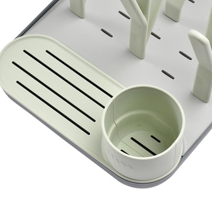 Green plastic cup holder with a small cup on a white background