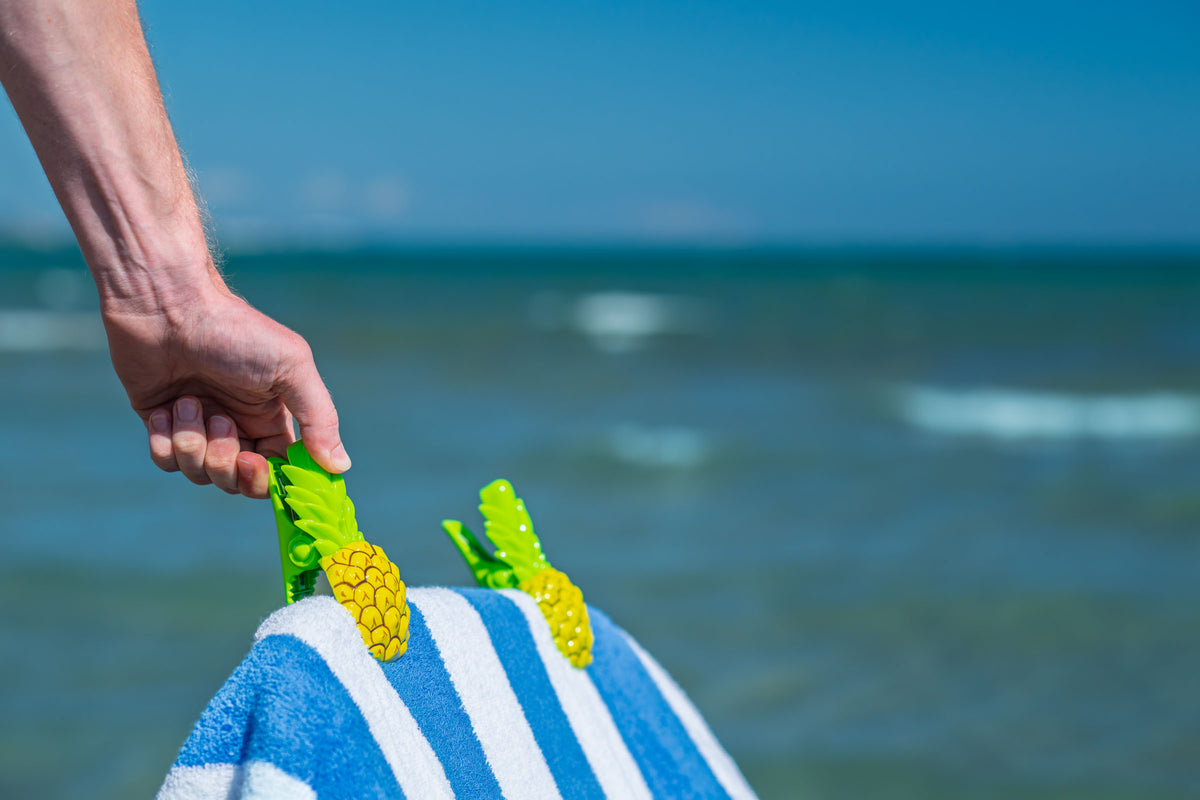 O2COOL Boca Clips Pineapple clipped to a lounge chair