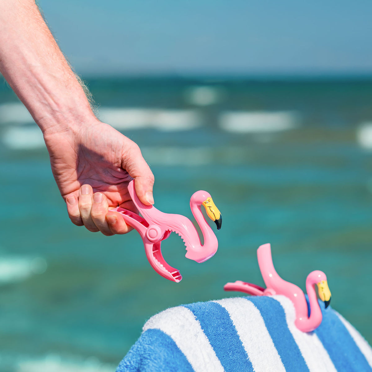 O2COOL Boca Clips Flamingo clipped to a lounge chair