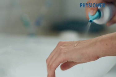 Spraying Physiomer Baby solution on the hand to test the pressure