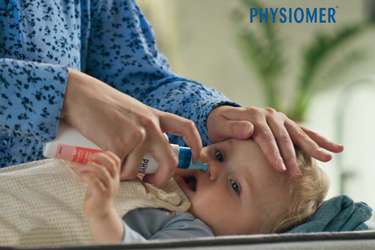 Physiomer Baby nasal spray being used on a baby's nostril